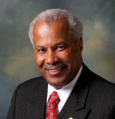 Man in a pinstripe blazer and a red tie.