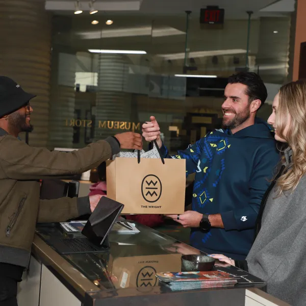 Man handing another man a shopping bag