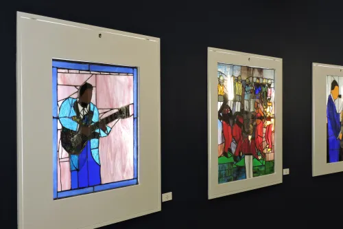 Stained glass pieces depicting musician and dancers.