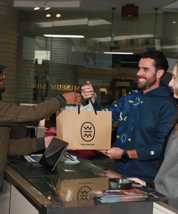 Man handing another man a shopping bag